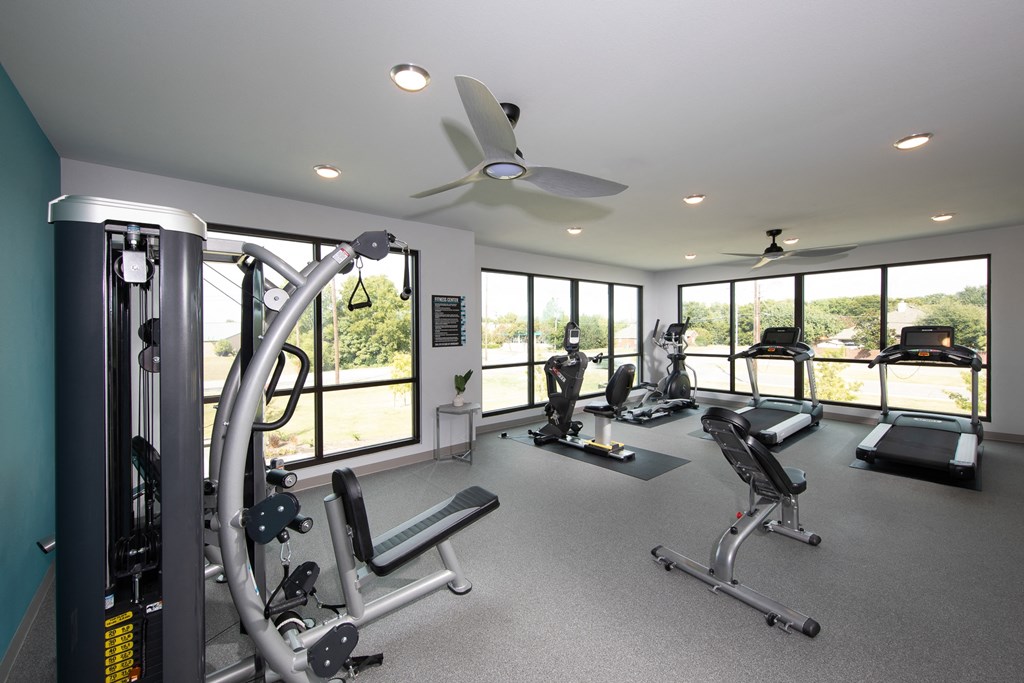 a gym with exercise equipment and windows in a house