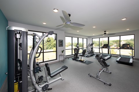 a gym with workout machines and equipment at a senior apartment community