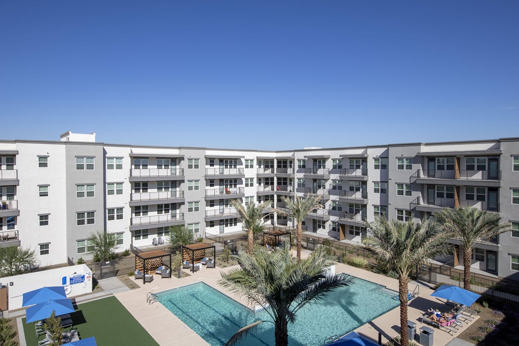 an overhead view of an apartment building with a pool and palm trees