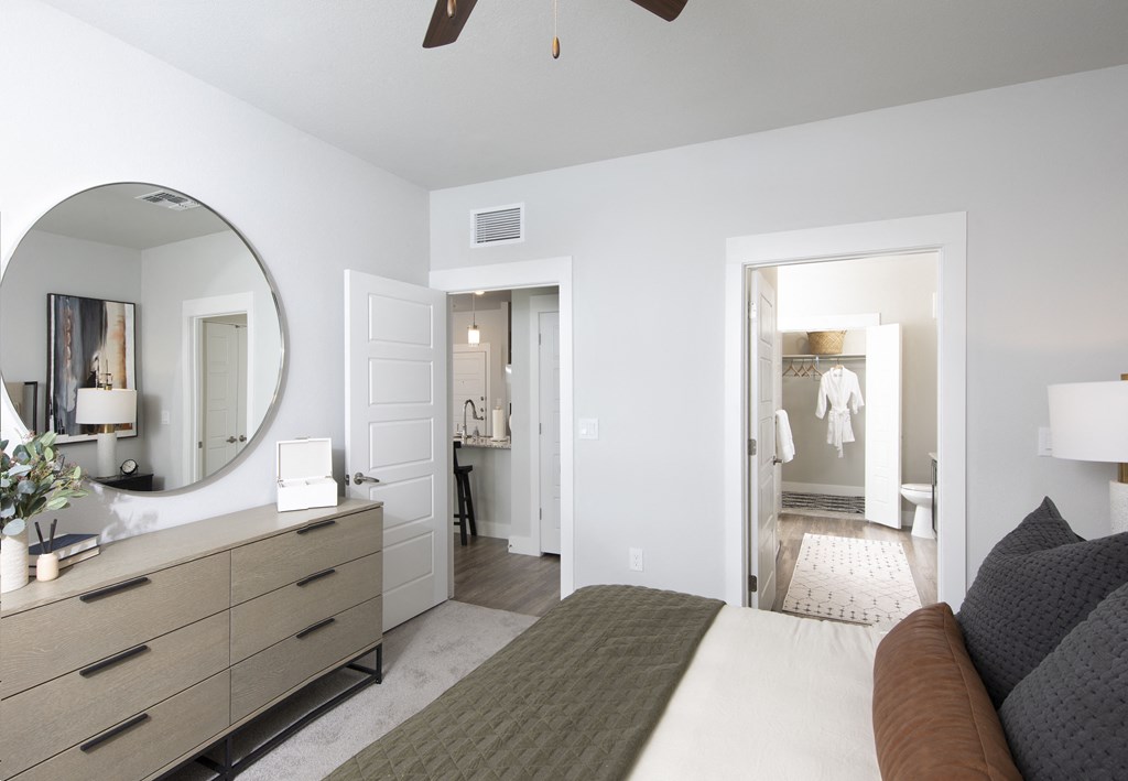 a bedroom with a bed and a dresser with a mirror on it