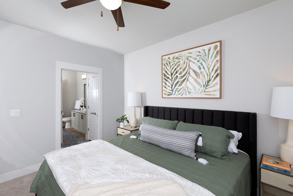 a bedroom with a queen-sized bed and ceiling fan at a senior apartment community