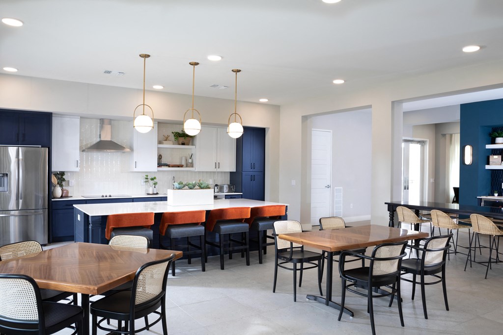 a community clubhouse dining room opening up to a kitchen at a senior apartment community