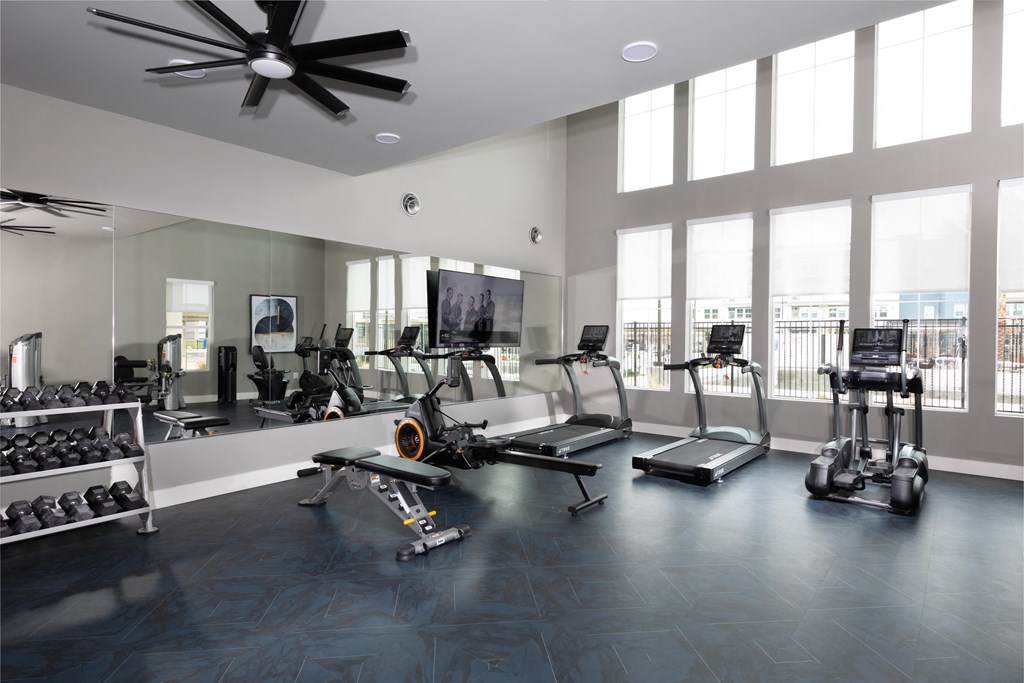 a gym with workout machines and equipment at a senior apartment community