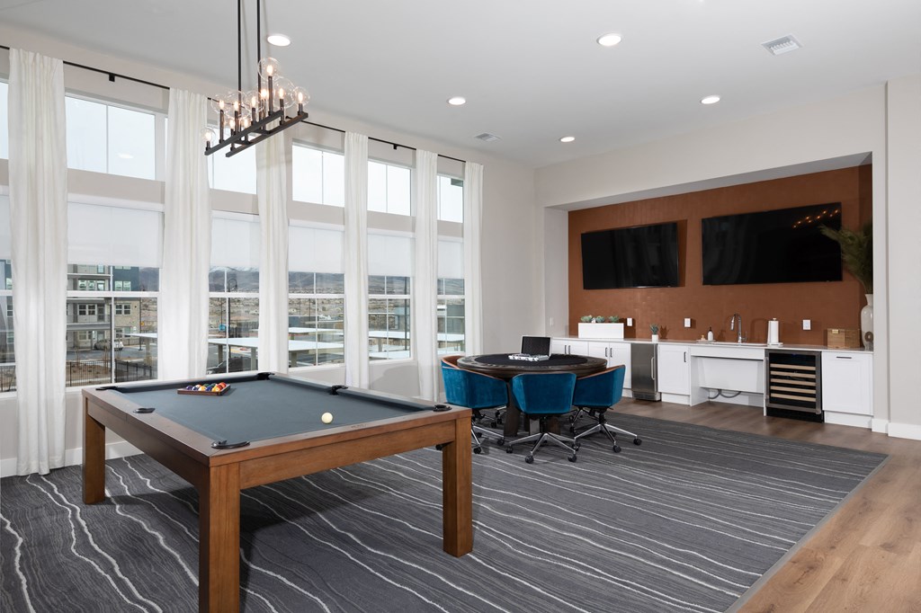 a game room with a pool table and seating at a senior apartment community