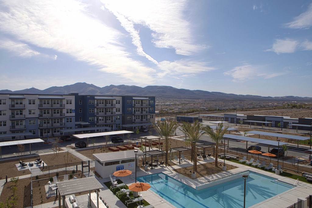 an aerial view of a resort-style pool and lawn at a senior apartment community