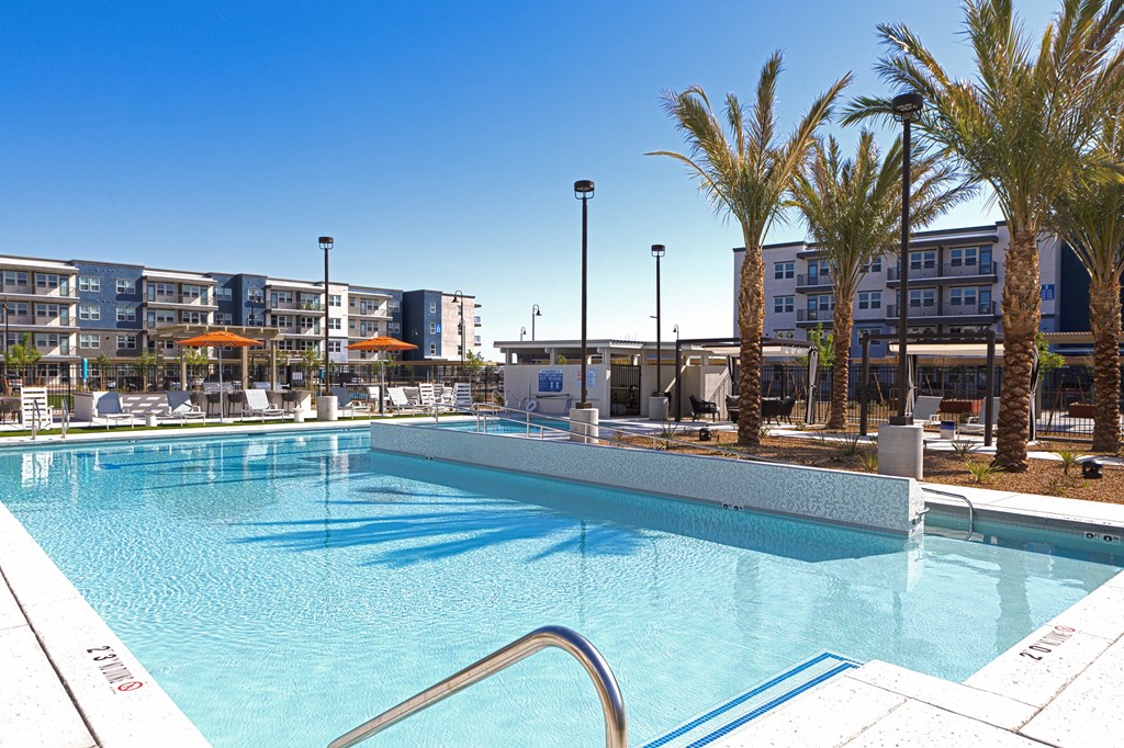 a resort-style pool with lounge areas at a senior apartment community