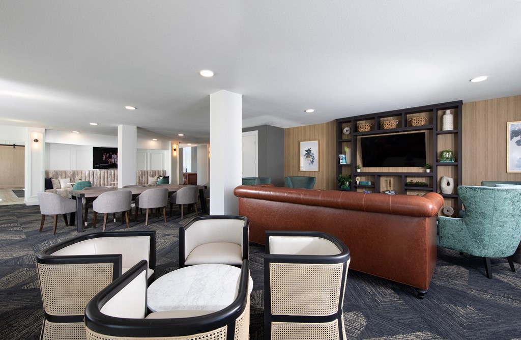 a lounge area with a couch and chairs and a table with chairs