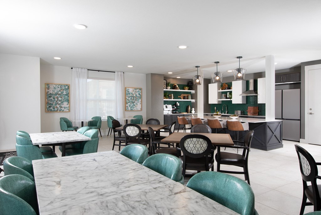 an open concept kitchen and dining room with marble tables and green chairs