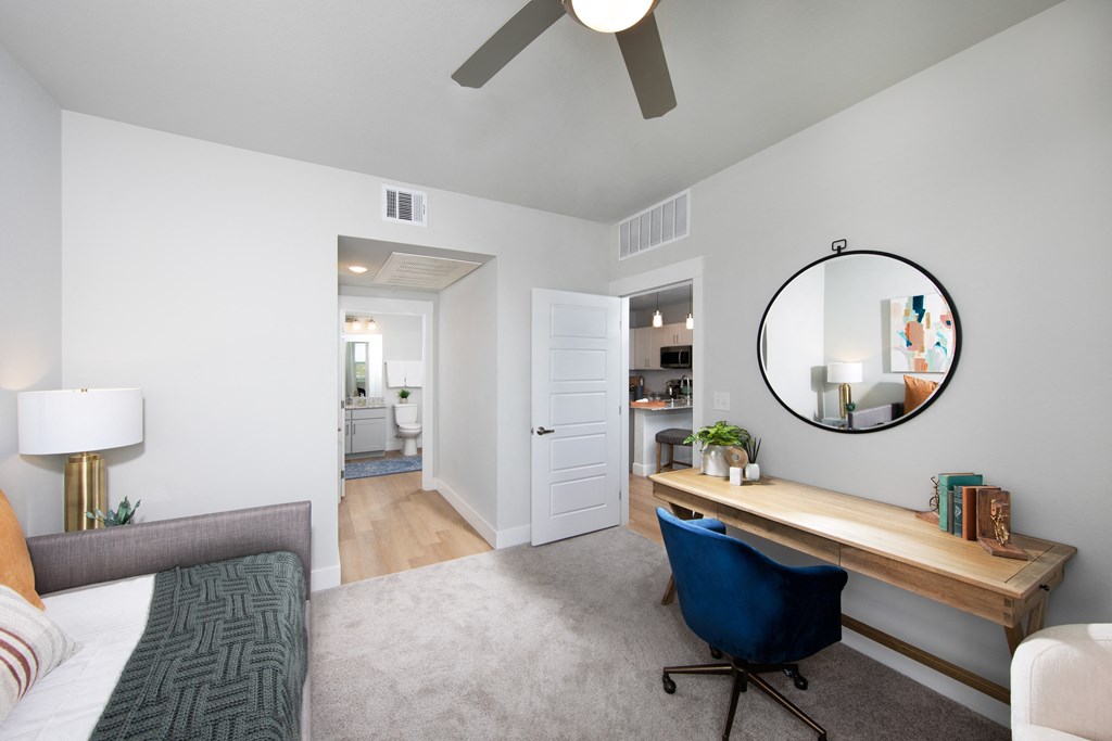 a bedroom with a bed and a desk with a mirror