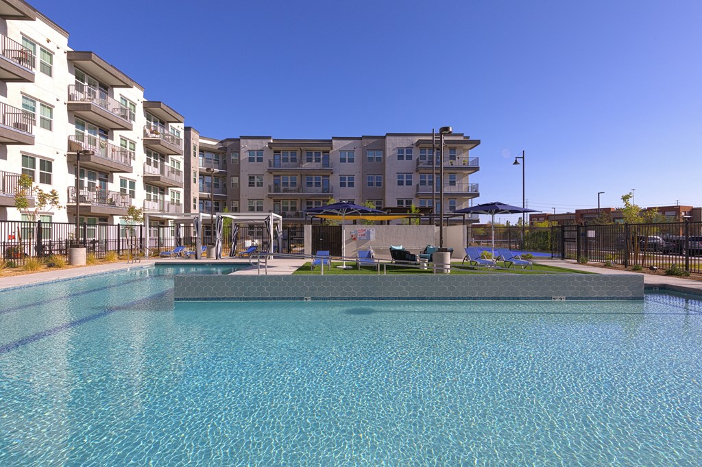 a swimming pool with an apartment building in the background