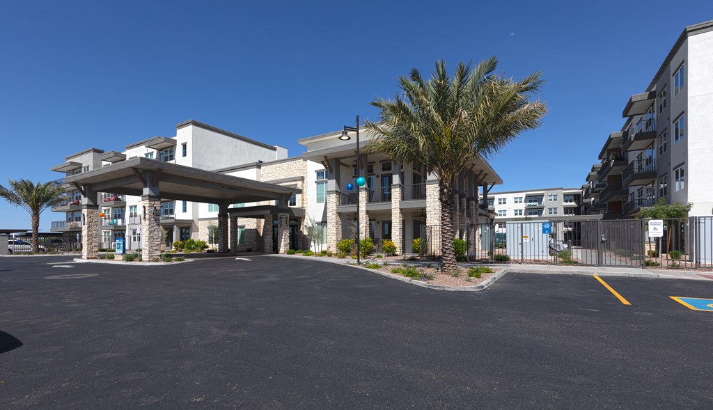a building with palm trees and a road in front of it