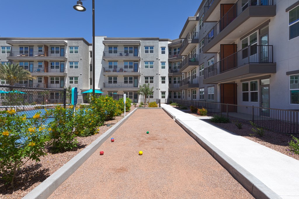 a walkway between two apartment buildings with balls on the ground