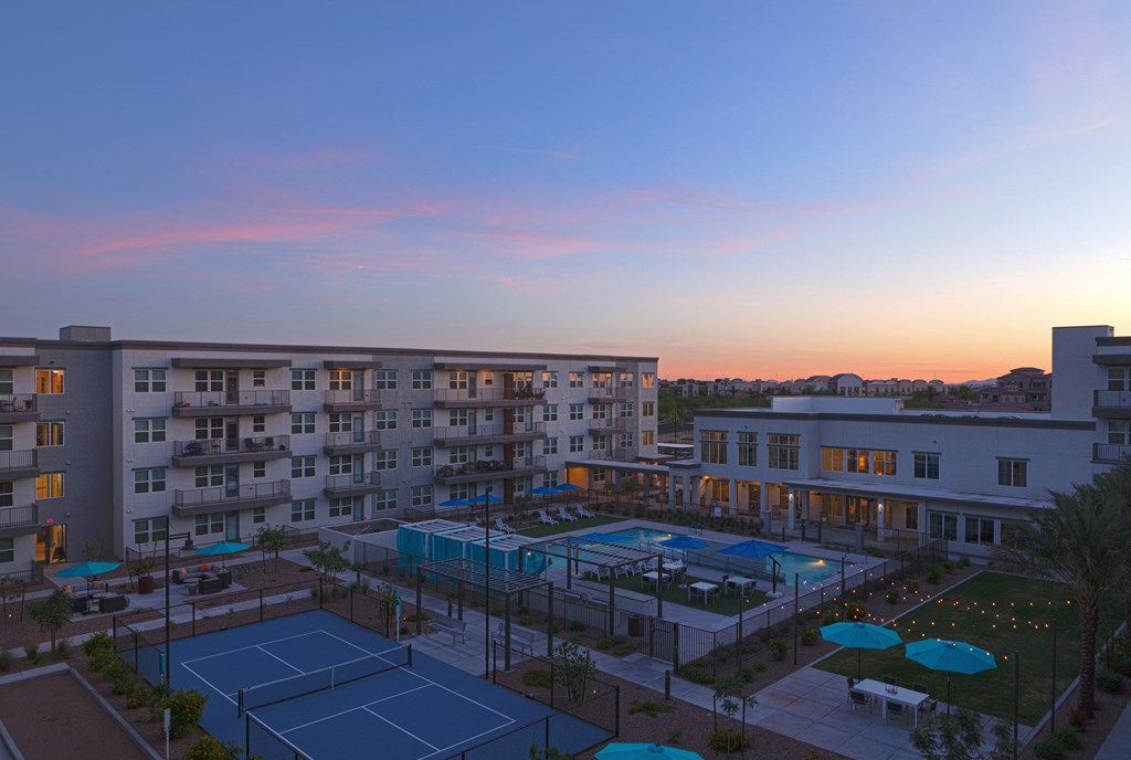 a view of the tennis court of a building at sunset