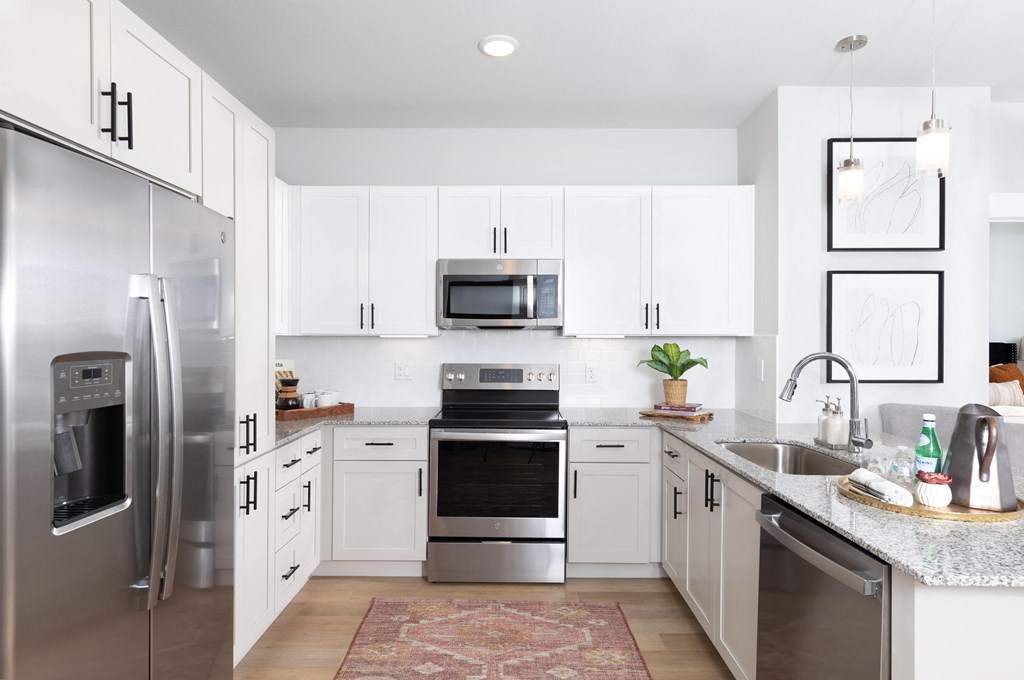 a modern kitchen with stainless steel appliances and white cabinets