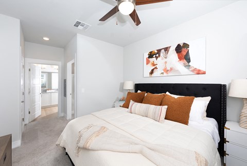 a bedroom with a queen-sized bed and ceiling fan at a senior apartment community