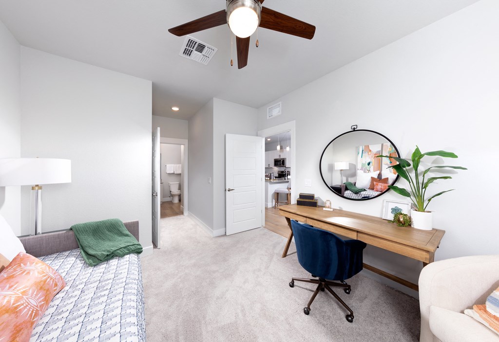 a bedroom with a bed and a desk with a mirror