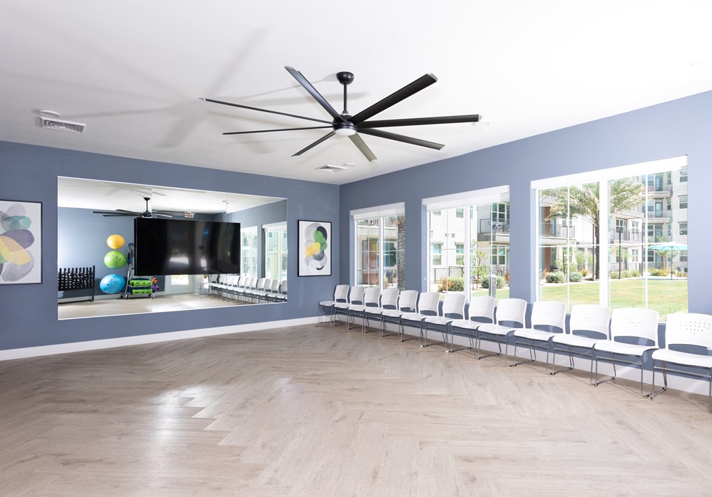 a large room with chairs and a large ceiling fan
