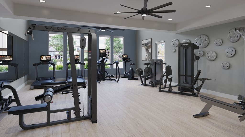 a spacious fitness room with cardio machines and weights