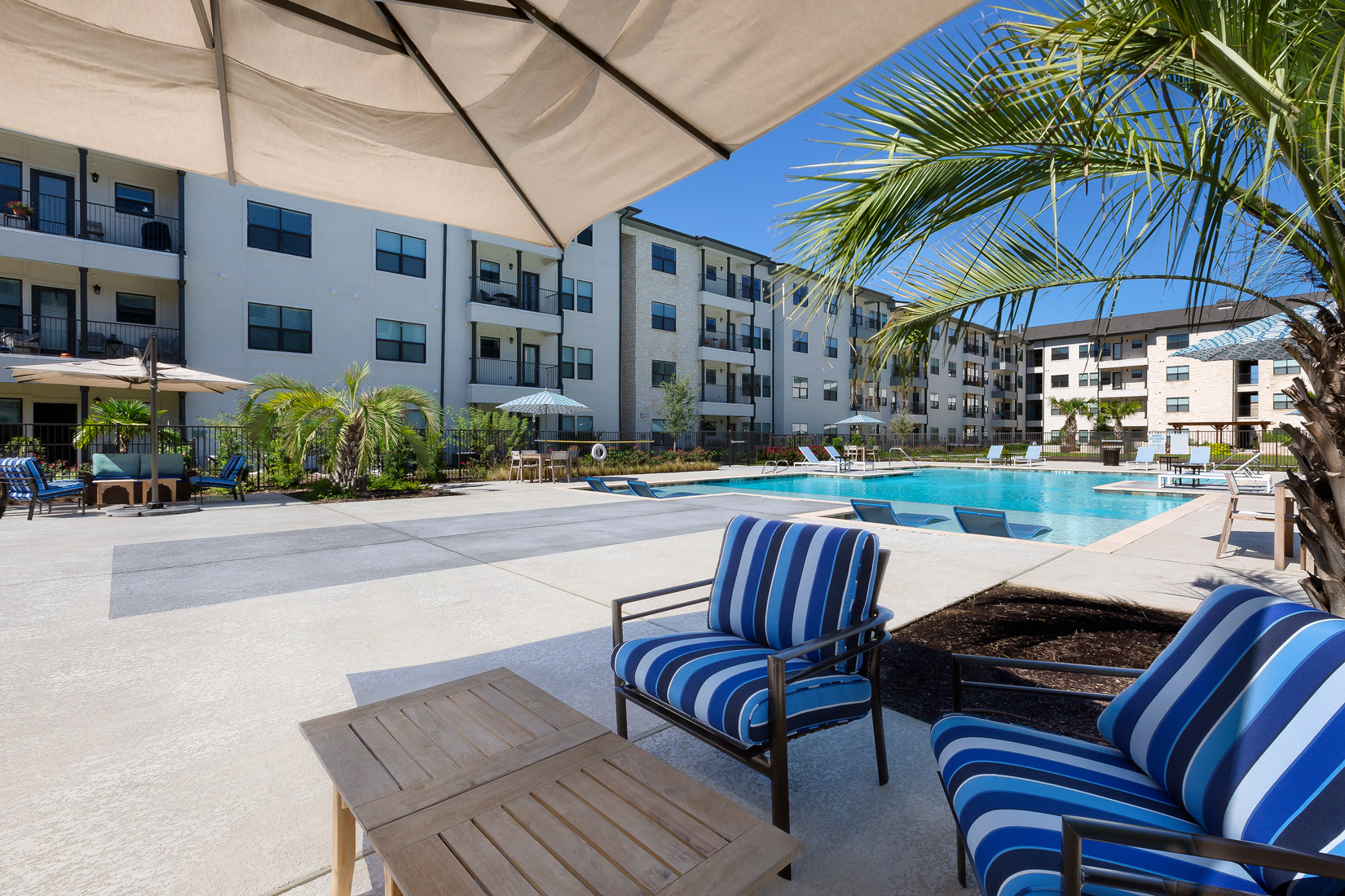 Poolside shaded social seating at Cedar Park Senior Apartments in Cedar Park Texas