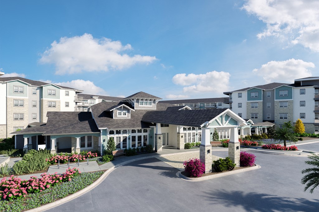 a rendering of a large apartment complex with a driveway and flowering shrubs