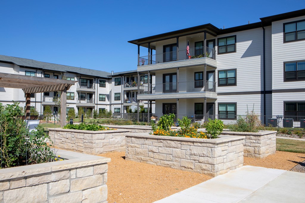 an exterior view of an apartment building with landscaping