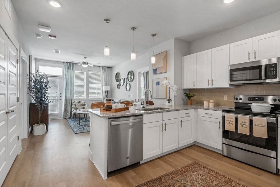 a large kitchen with white cabinets and stainless steel appliances