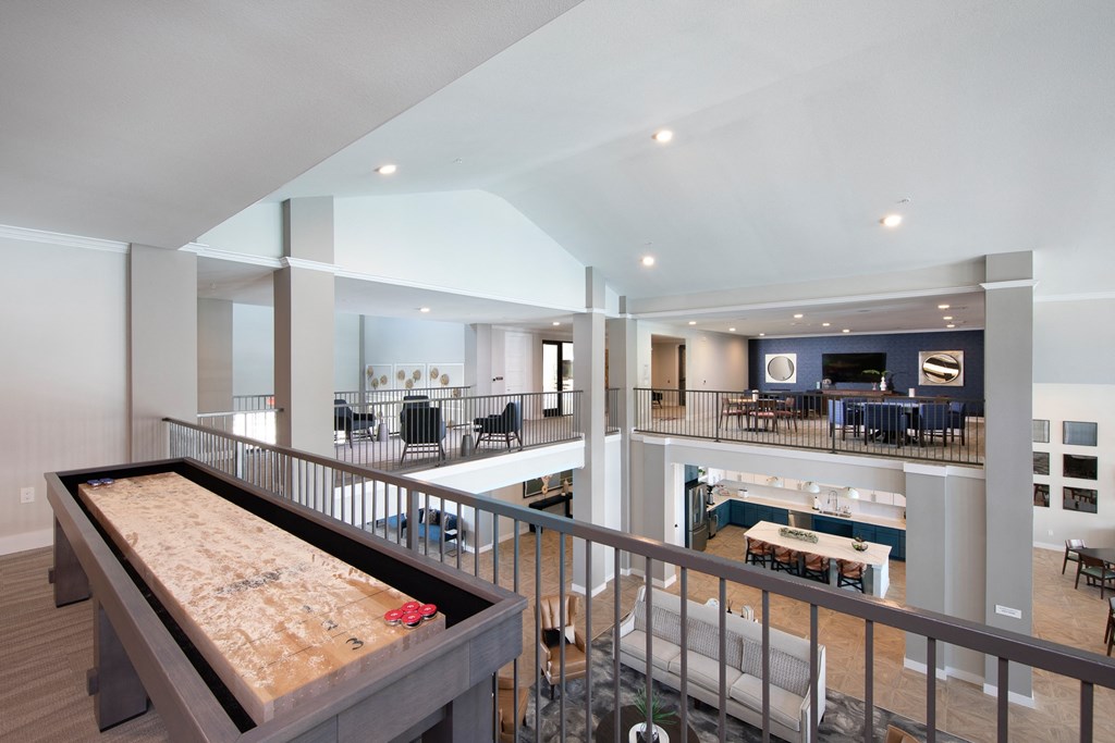 a large living room with a shuffleboard table and a dining room
