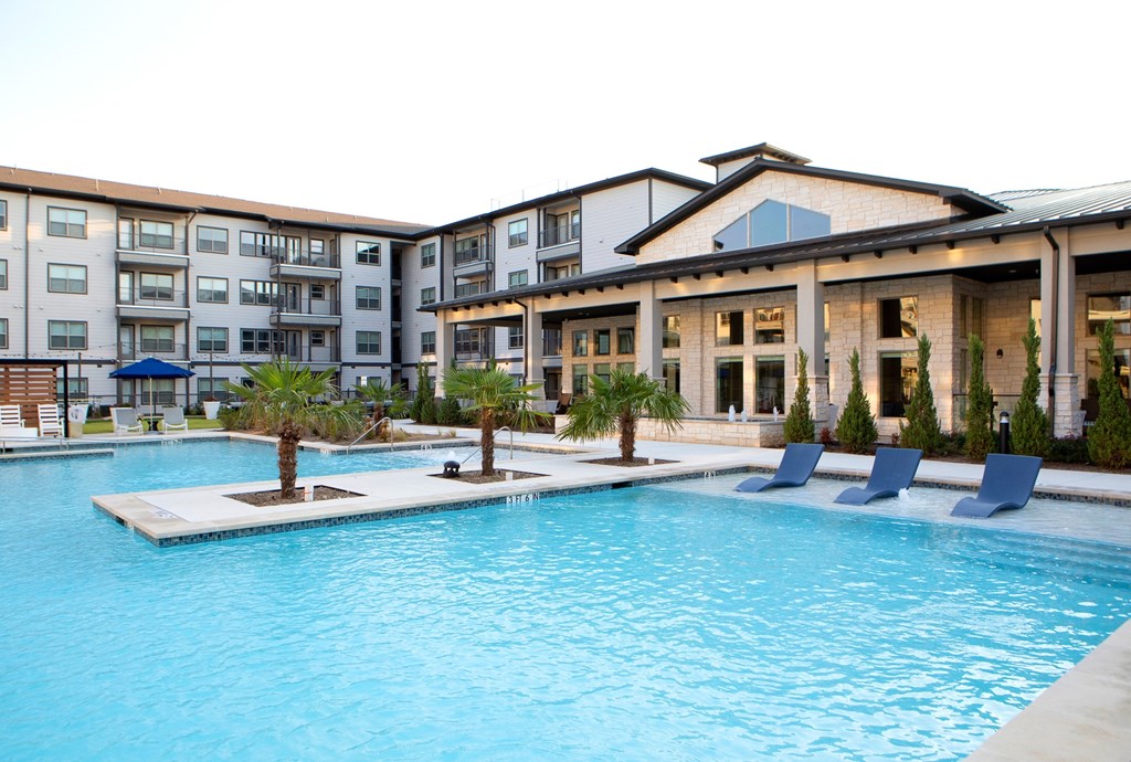 a large swimming pool in front of an apartment building