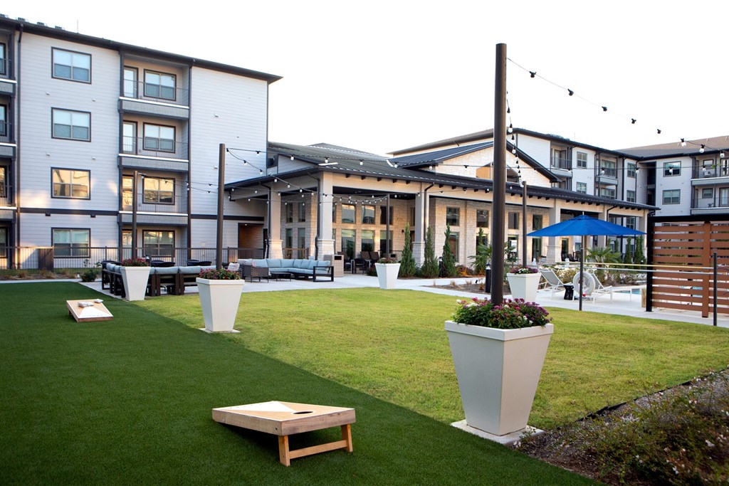 a grassy area with benches and a building in the background