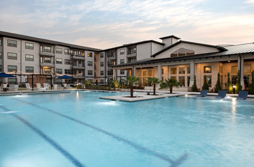 a large swimming pool with buildings in the background