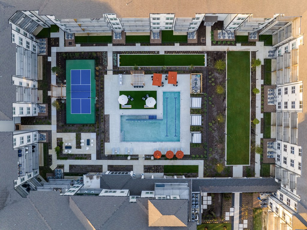 an aerial view of a building with a pool in the middle