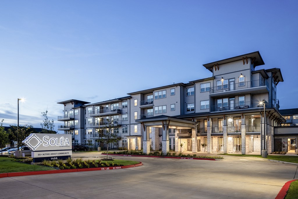 a large apartment building at night with a sold sign