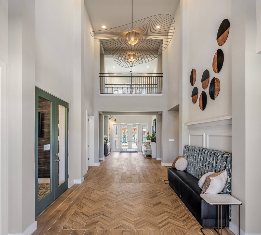 a long hallway with a couch and a chandelier