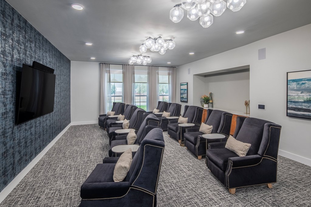 a large screening room with blue couches and chairs