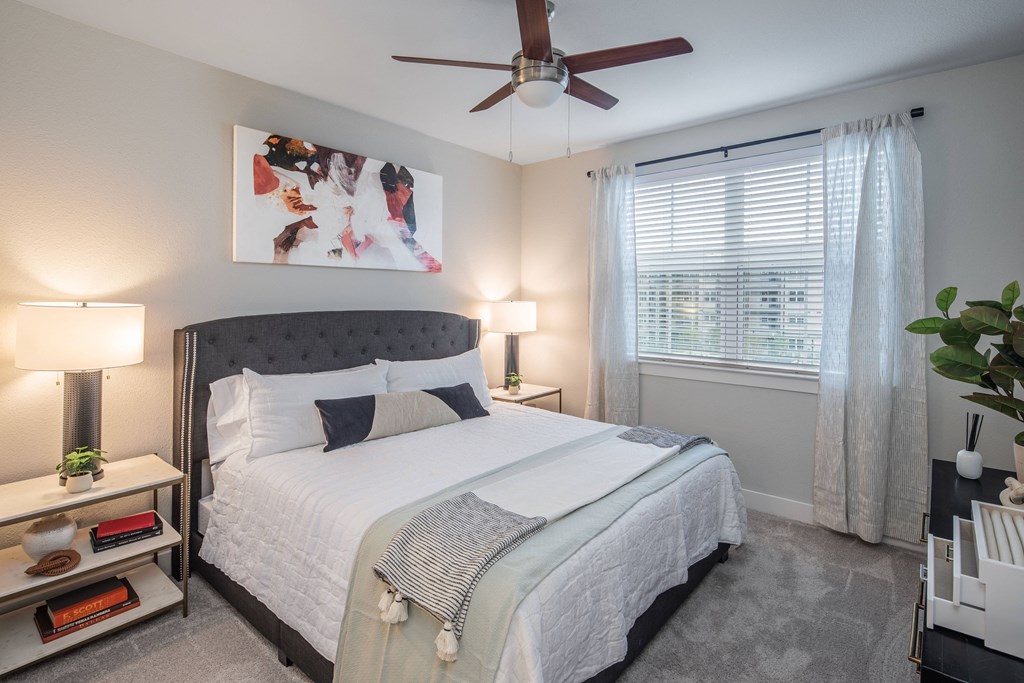 a bedroom with a large bed and a ceiling fan