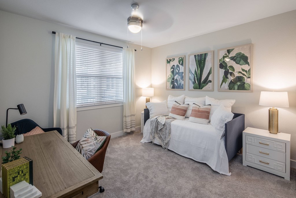 a bedroom with a bed and a desk and a window