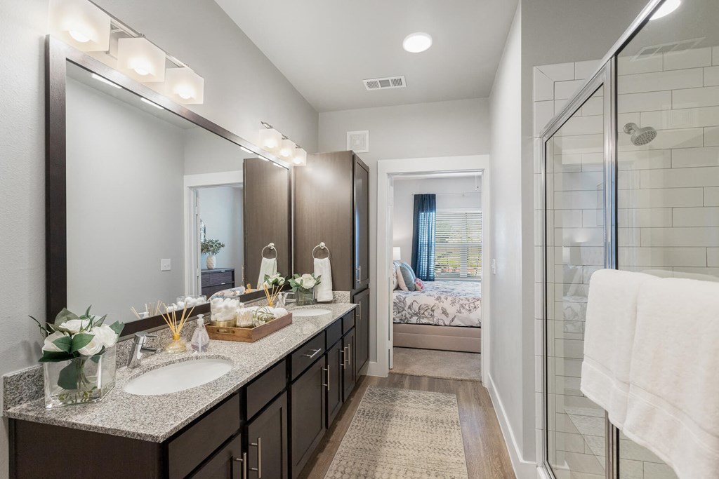a bathroom with two sinks and a shower at a senior apartment community