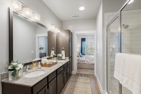 a bathroom with two sinks and a shower at a senior apartment community