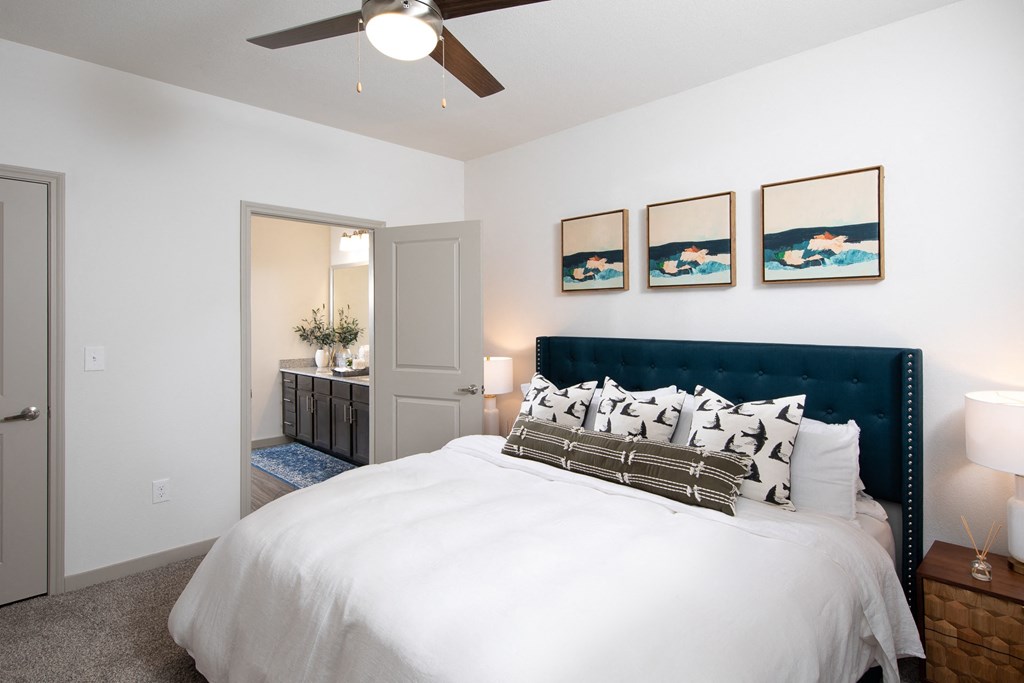 a bedroom with a queen-sized bed and ceiling fan at a senior apartment community