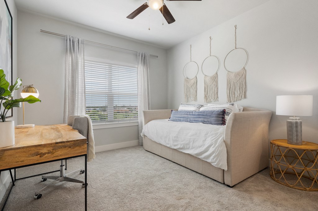 a bedroom with a bed and a chair and a desk