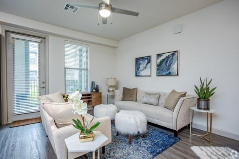 A living room with a white couch, a coffee table, and a rug.