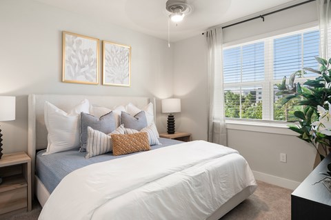 A bedroom with a large bed and two framed pictures on the wall.
