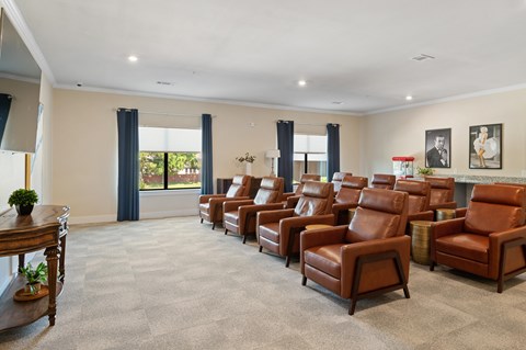 A room with brown leather chairs and a carpeted floor.