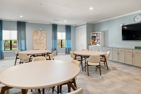 A dining room with a large table and chairs.