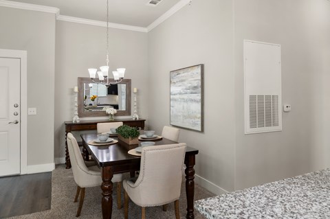 A dining room with a table set for four.