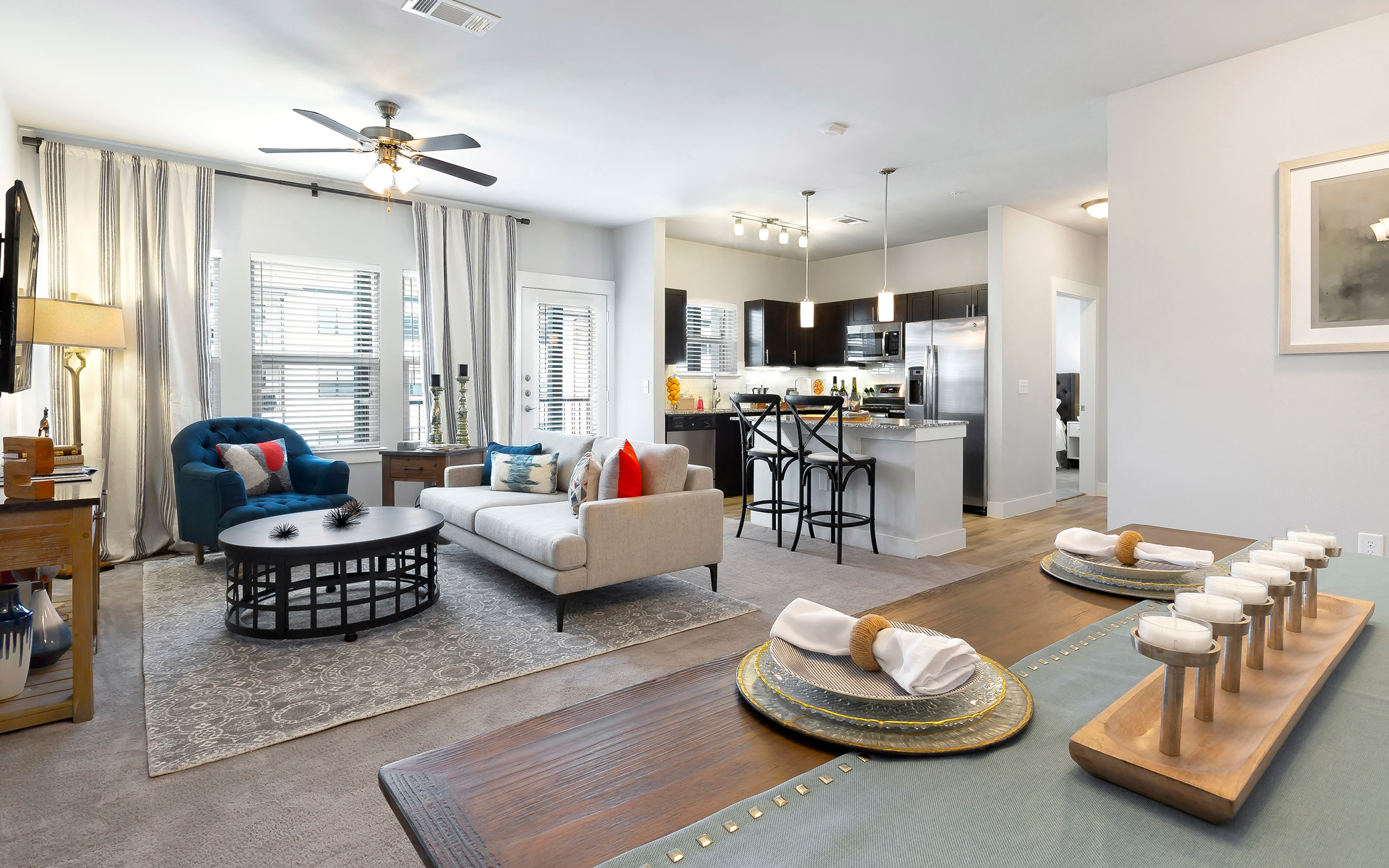 a living room with furniture and a kitchen in the background