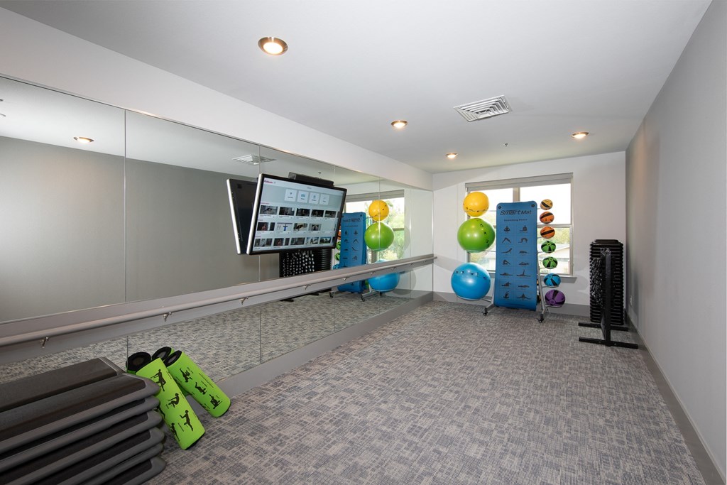 a fitness room with workout equipment at a senior apartment community