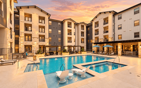 A large swimming pool surrounded by apartment buildings.