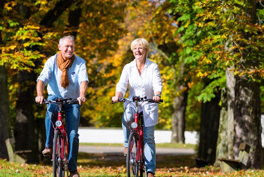 a man and a woman riding bikes in a park