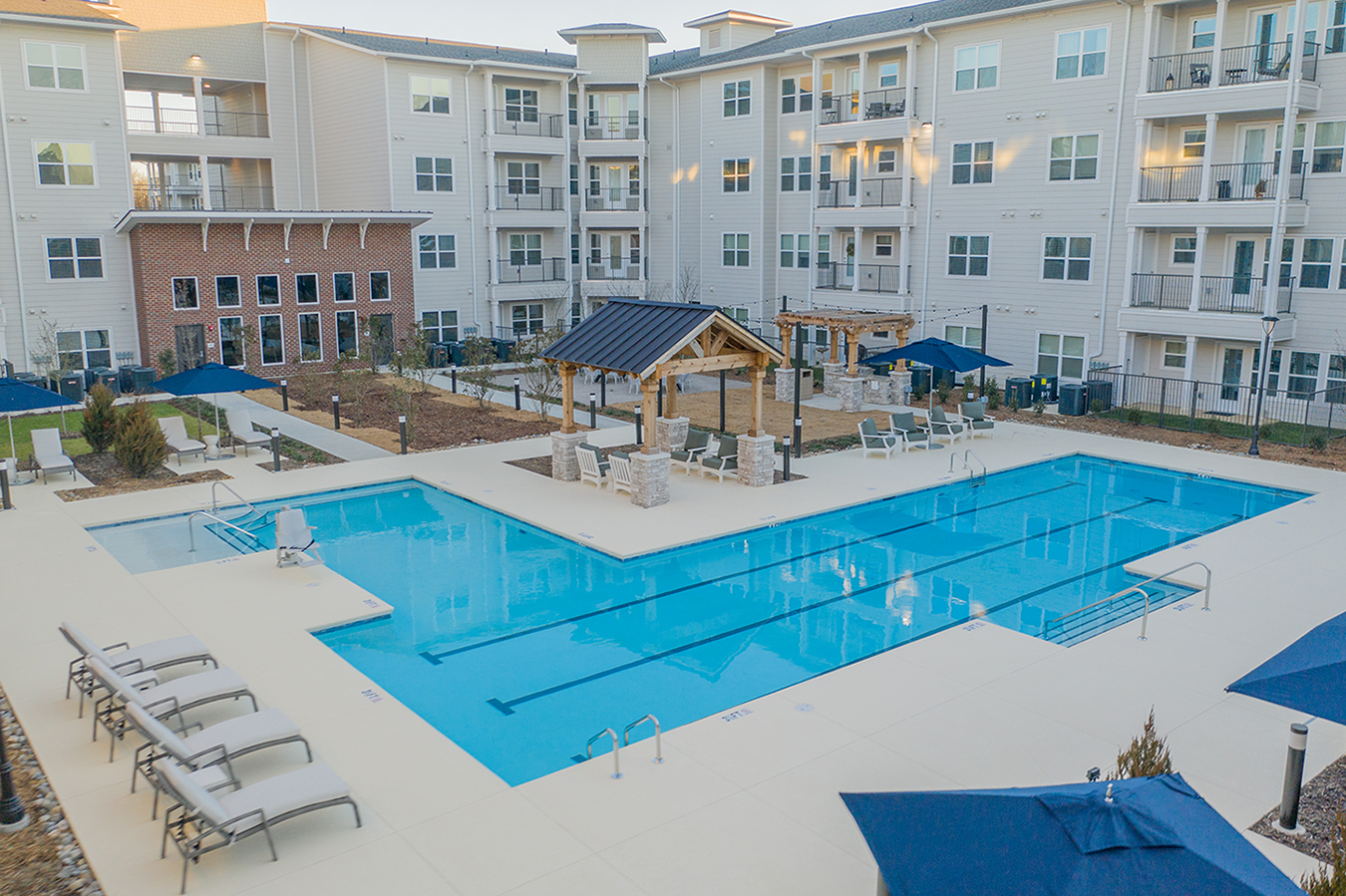 an overhead view of a swimming pool with an apartment building in the background